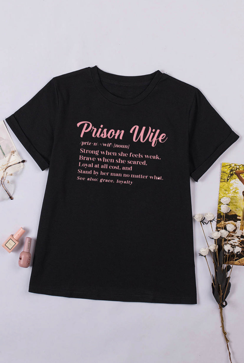 A prison wife tshirt with a definition that reads "Prison Wife: A woman that's strong when she feels weak, brave when she feels scared, loyal at all cost and will stand by her man no matter what. Also see, grace, loyalty." It's a powerful reminder of the strength and resilience of prison wives, and a celebration of the qualities that make them so special